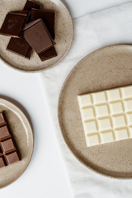 Free Top view of composition of delicious sweet chocolate on ceramic plates on table Stock Photo