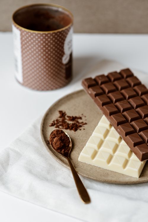 Free High angle of various chocolate and spoon with cocoa powder on modern ceramic plate Stock Photo