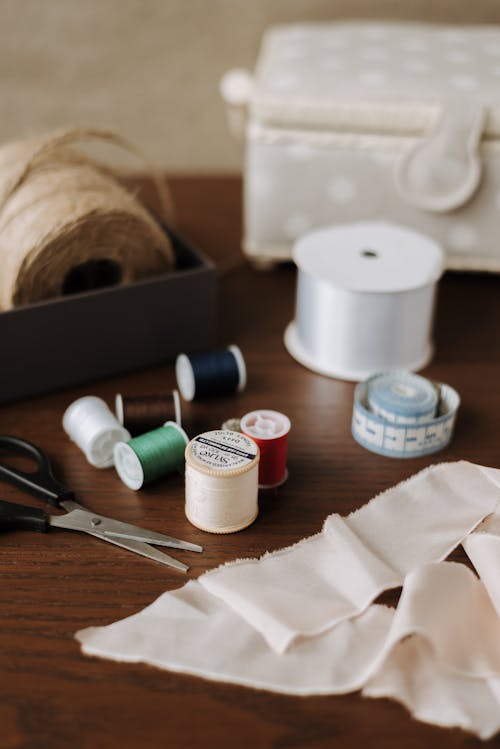 High angle of collection of various sewing stuff on wooden table at home