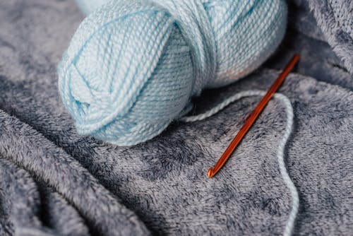 Blue yarn and hook on blanket