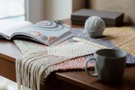 Yarn near opened magazine and mug
