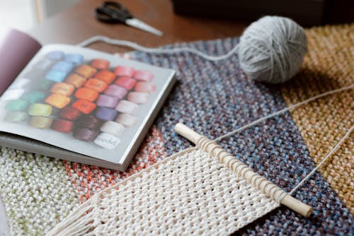 Free Beige knitted handmade piece near magazine Stock Photo