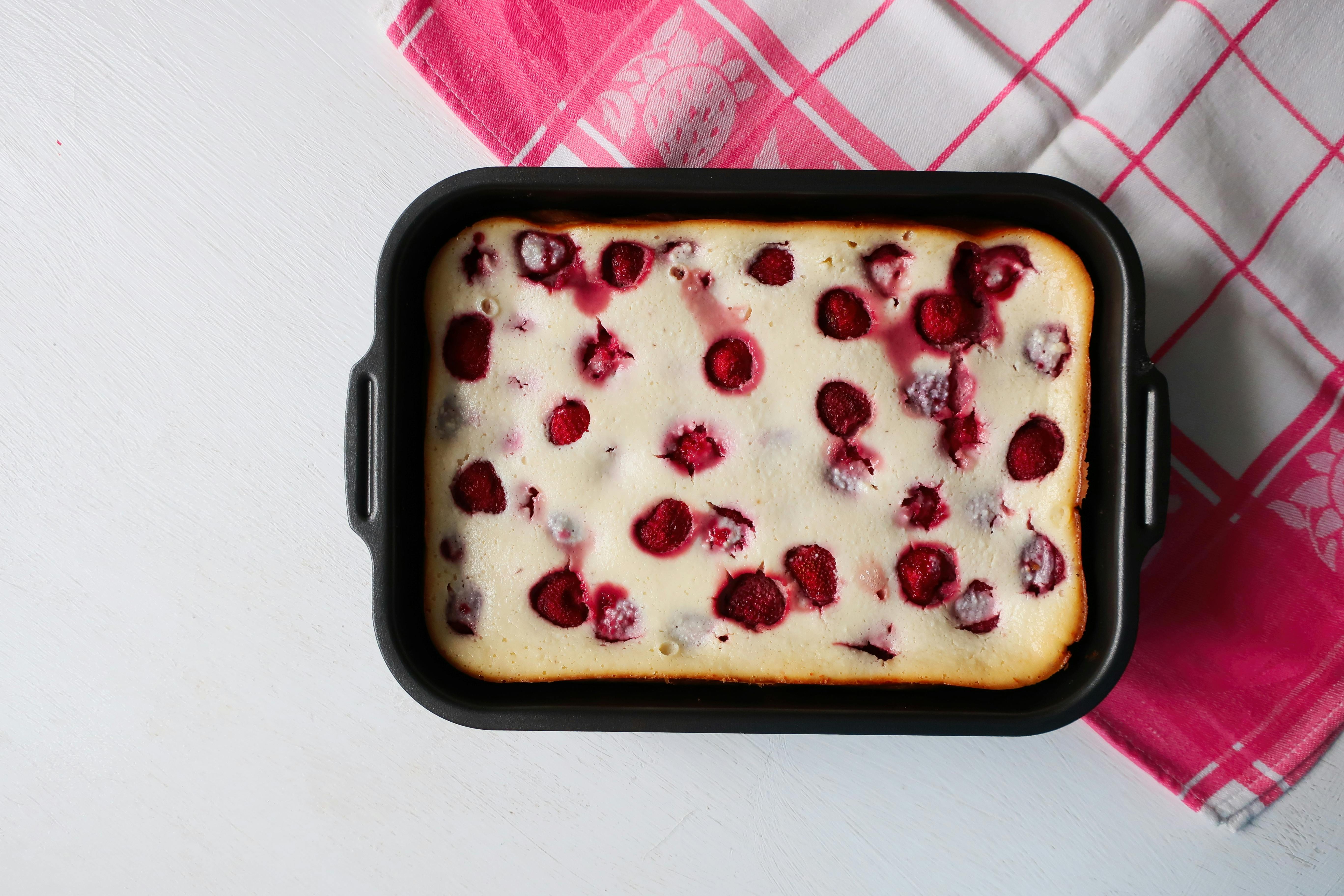 Delicious homemade raspberry cake in a baking tray on a checkered cloth.