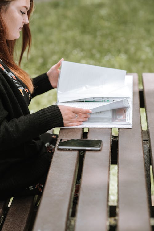 Mujer De Cultivo Leyendo Materiales De Aprendizaje En El Parque