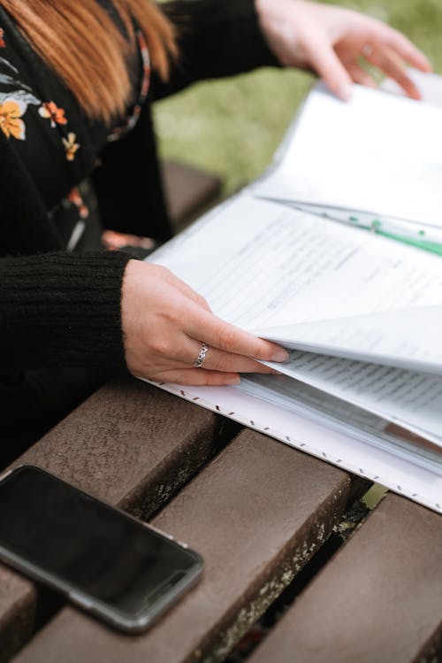 Femme Examinant Des Documents Importants Sur Un Banc En Bois