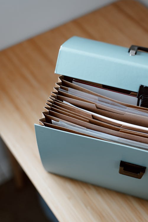 Free From above of opened modern briefcase with prepared papers placed on timber table in soft focus Stock Photo