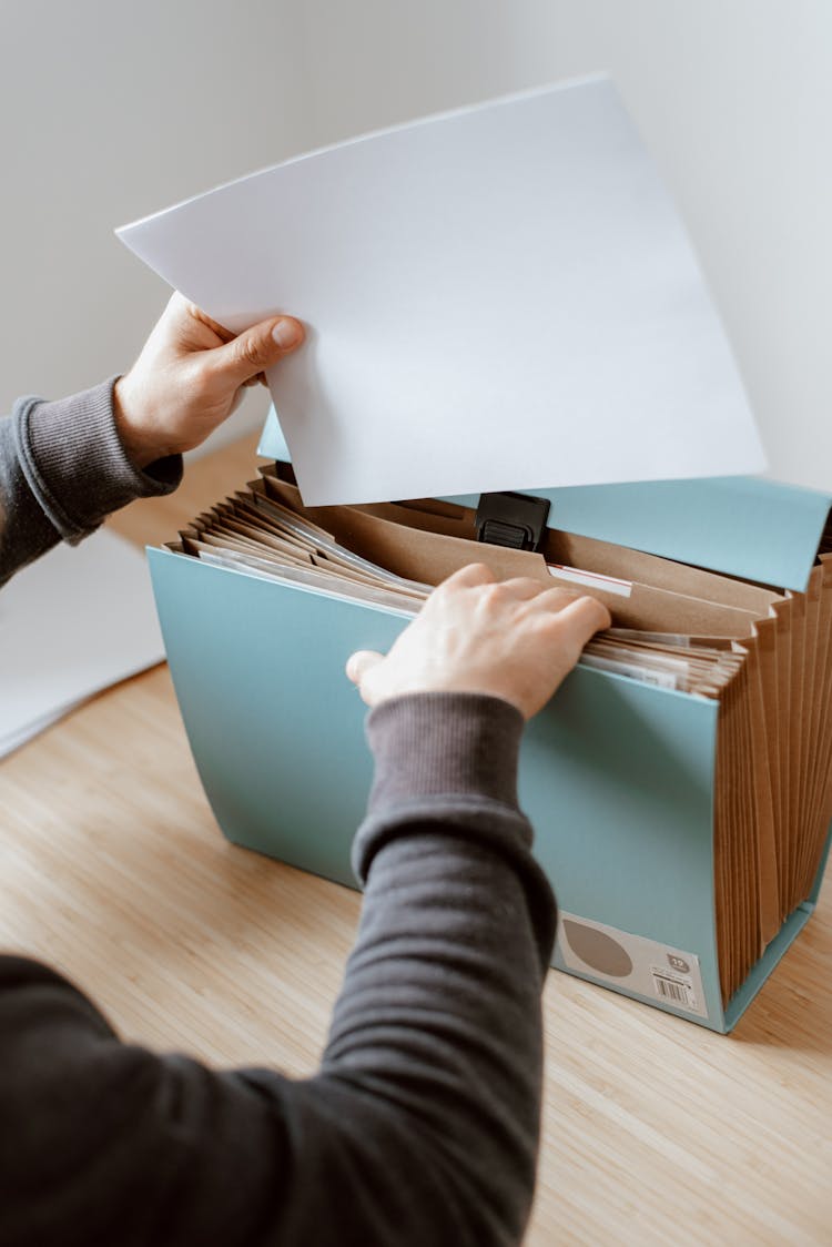 Man Opening Blue Briefcase With Documents