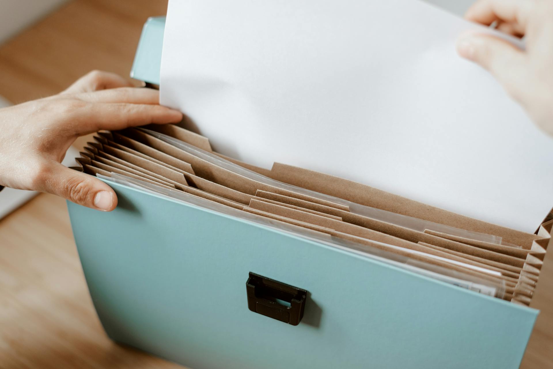 Person taking white paper from folder