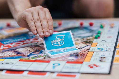 Free Person Picking Monopoly Cards Stock Photo