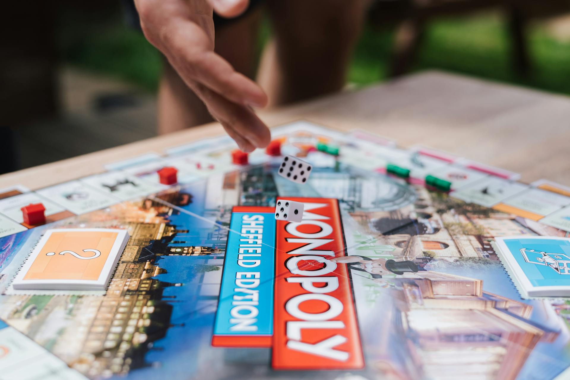 Close Up Photo of Rolling of Dice on Monopoly Board Game