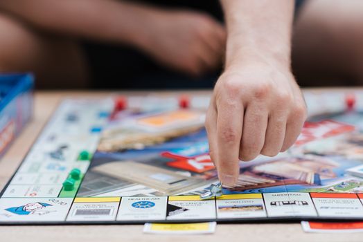 一个人在室内玩《大富翁》，在棋盘上移动棋子
