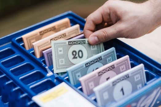 在游戏过程中，将大富翁游戏资金放入蓝色塑料托盘的手里