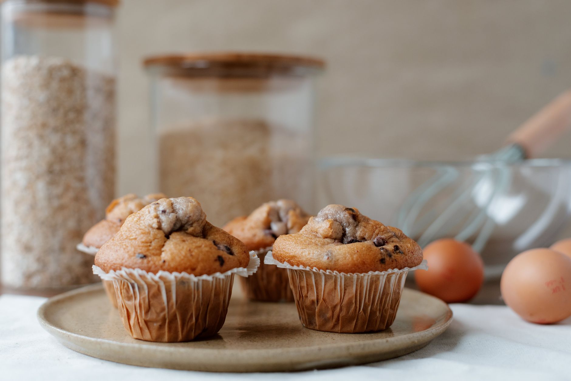 Freshly baked mini banana breads with chocolate chips cooling on wooden board