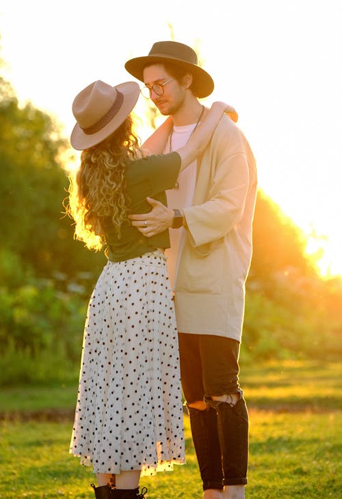 Young stylish loving couple embracing in countryside