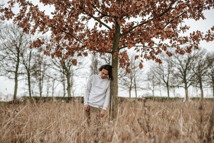 Man Leaning Against A Tree