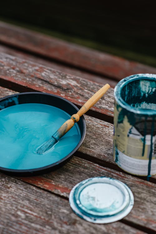 Bowl of paint near jar on bench