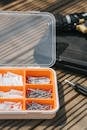 From above of various metal nails placed on wooden table near screwdriver in soft daylight