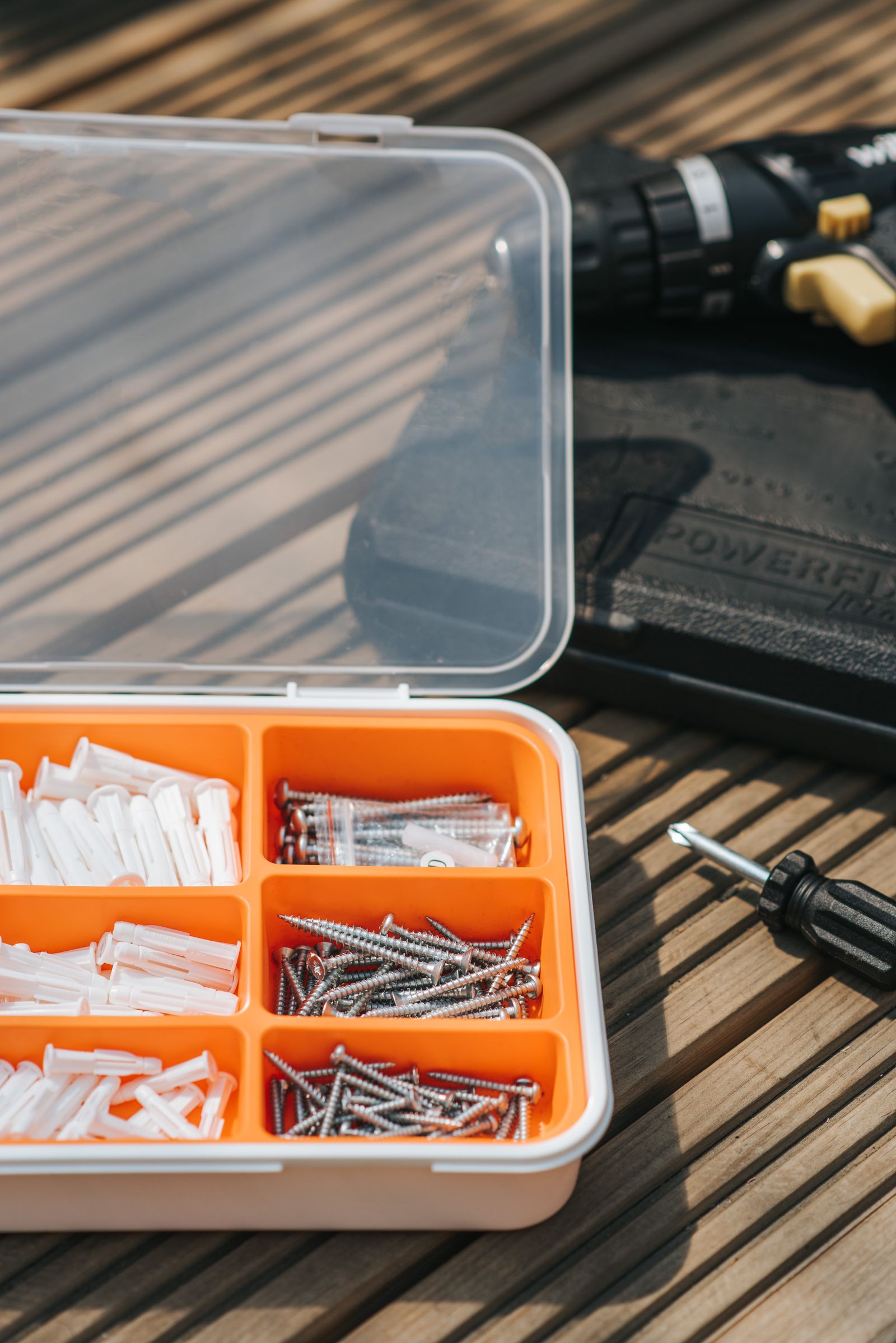 Repair tools, drill, screwdriver and hardware arranged on a workshop surface