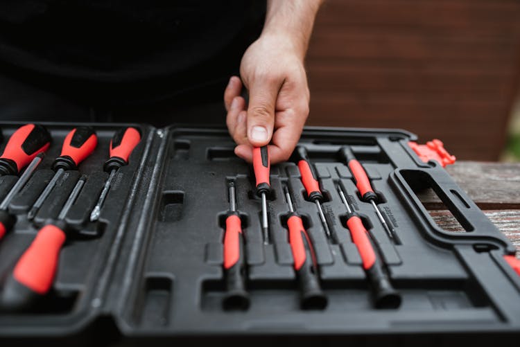 Faceless Master Choosing Screwdriver From Toolbox