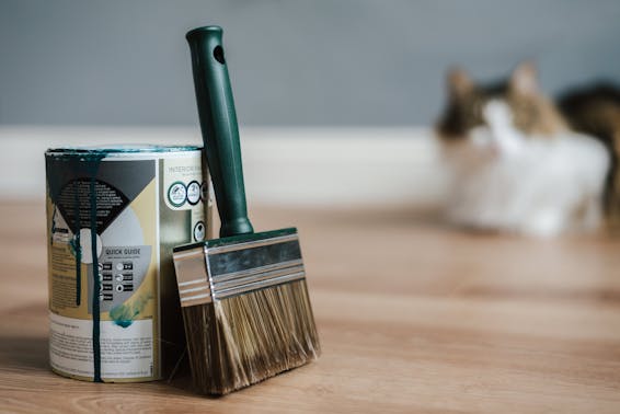 Paint brush near can on floor at home