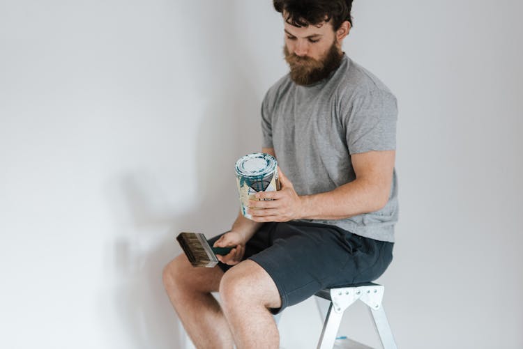 Crop Hipster Man With Can On Paint On Ladder