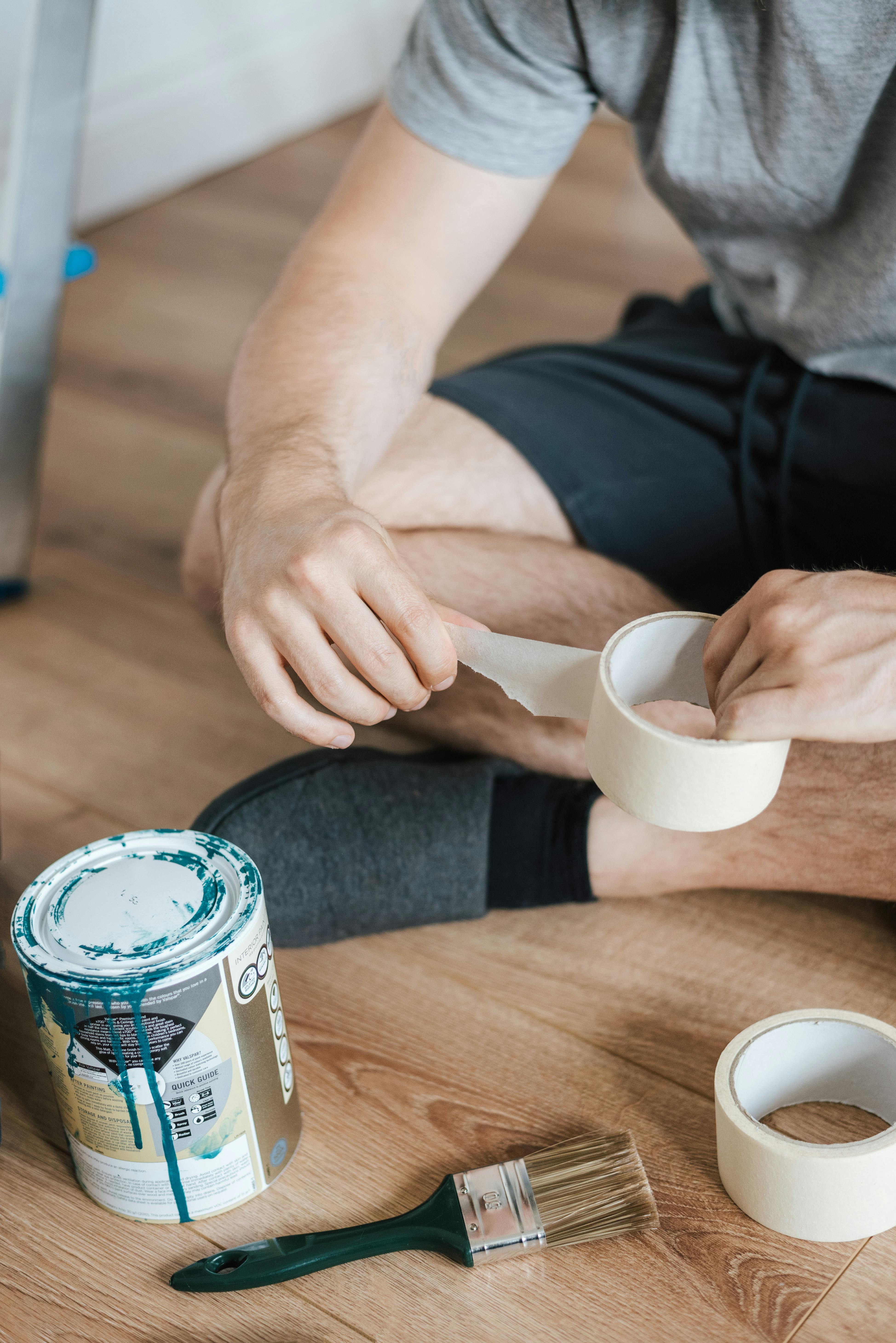 faceless man with scotch tape on floor in house