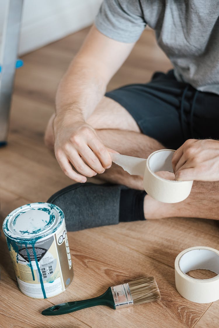 Faceless Man With Scotch Tape On Floor In House