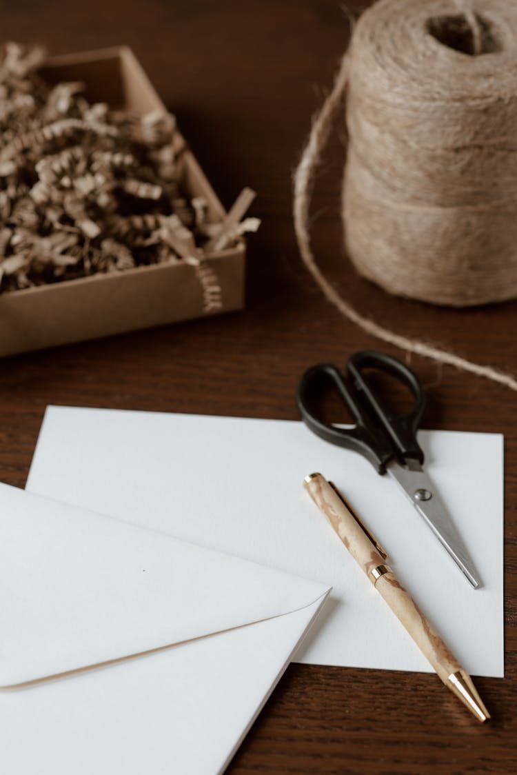 Handmade Envelope Near Pen And Scissors On Table