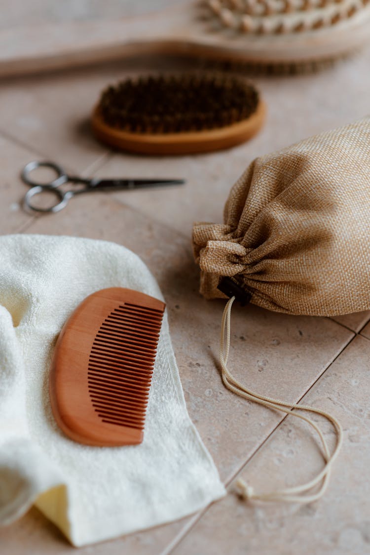 Fabric Bag Near Wooden Comb On Tiled Floor