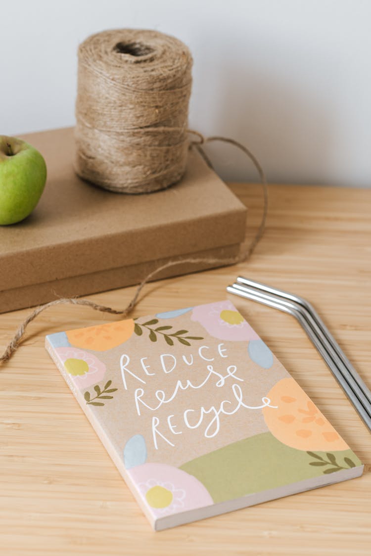 Book With Ornament Near Metal Tubes On Table