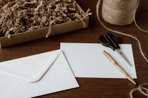 Envelope and pen placed on table near tying twine
