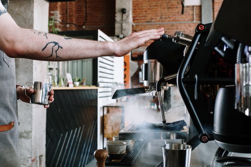 Free Close-up of a barista steaming milk at a coffee house with an espresso machine. Stock Photo