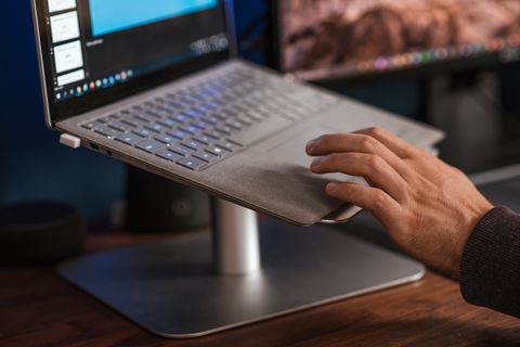 Aluminium laptop stand holding a laptop on a desk