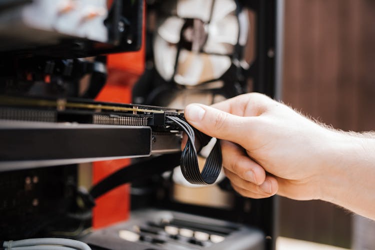 Crop Faceless Man Fixing Cables In System Unit