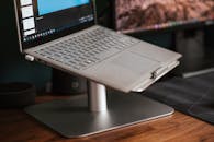 Modern laptop placed on stand on desk