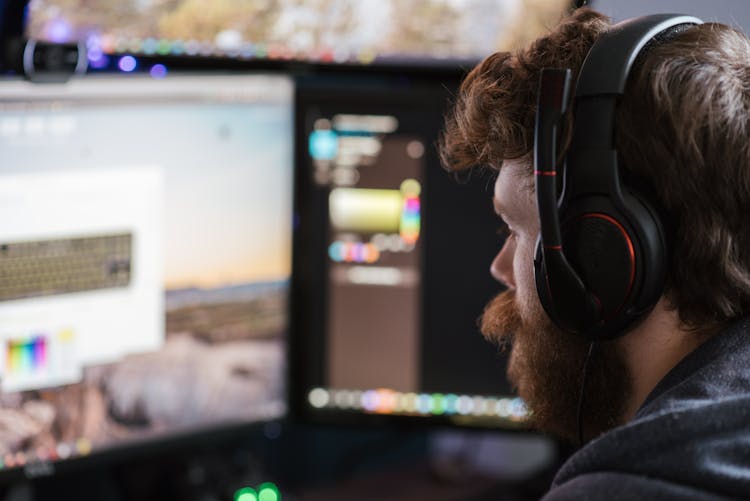 Crop Man In Headphones Working On Computer