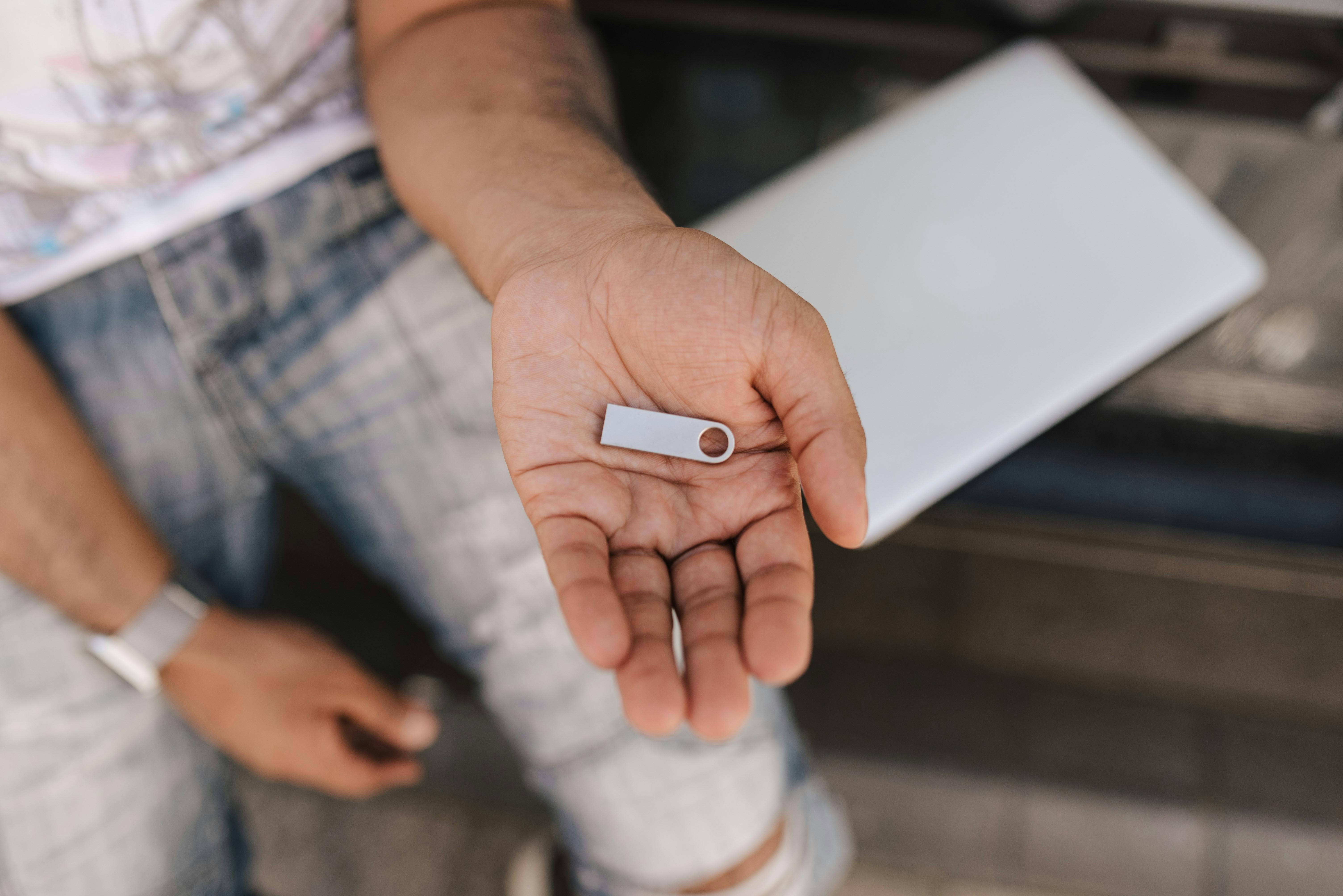 crop faceless man showing memory card on hand