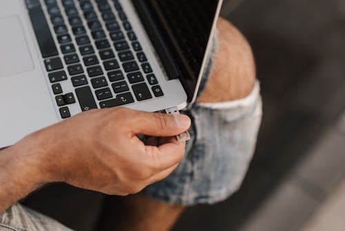 Male remote worker inserting USB stick into port