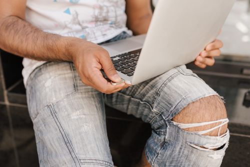 Free Crop anonymous male freelancer putting small electronic device containing flash memory in laptop port Stock Photo