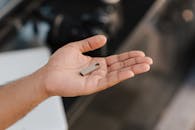 从上方看，一名匿名男性在手掌上展示现代便携式存储设备