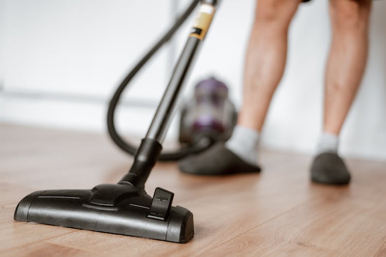 Man Cleaning Floor With Vacuum Cleaner