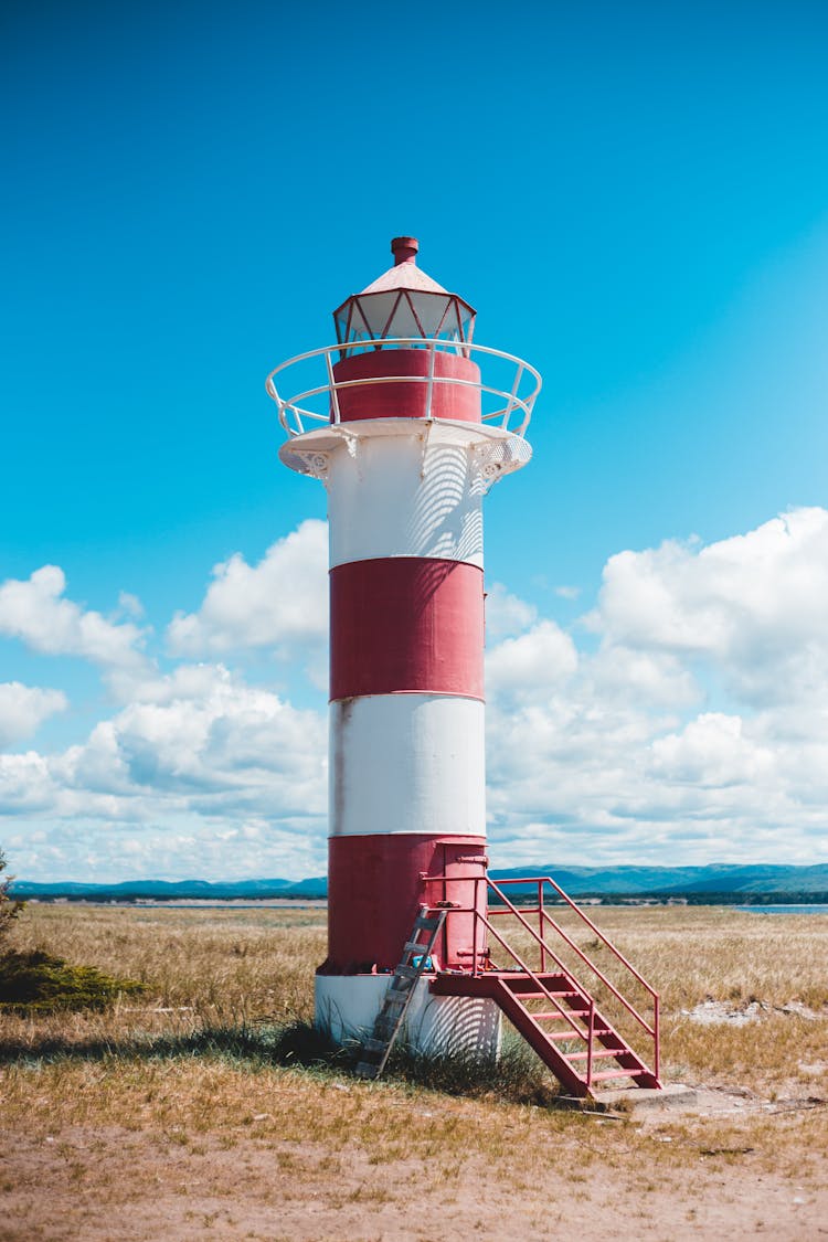 Colorful Beacon With Stairs On Grass Terrain Under Sky