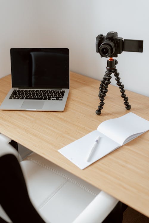 Modern video camera placed near netbook and notebook