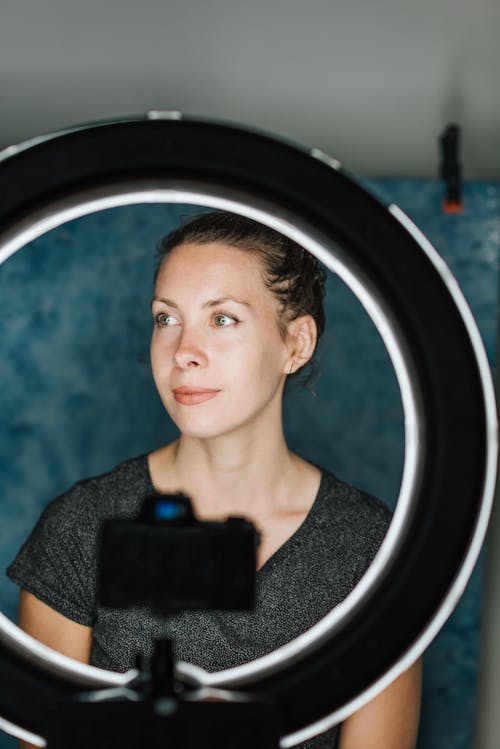 Free Woman taking self portrait with contemporary camera and studio lamp Stock Photo