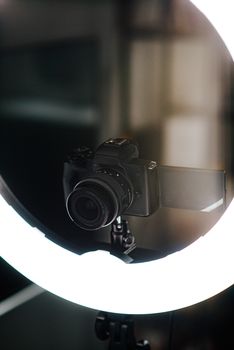 From above of modern photo camera near contemporary circle studio lamp on blurred background