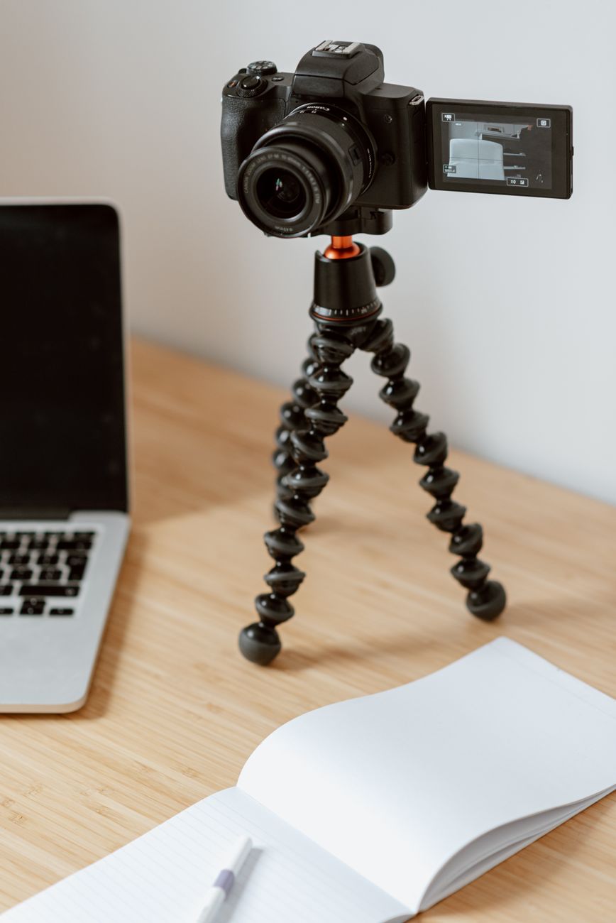 creative desk with camera notebook and laptop in a warm studio