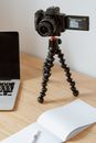 Camera on tripod recording video on table