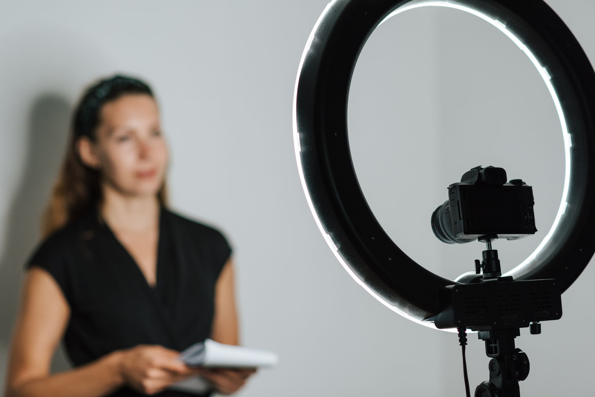 Professional journalist with notepad sharing information on camera in studio on white background