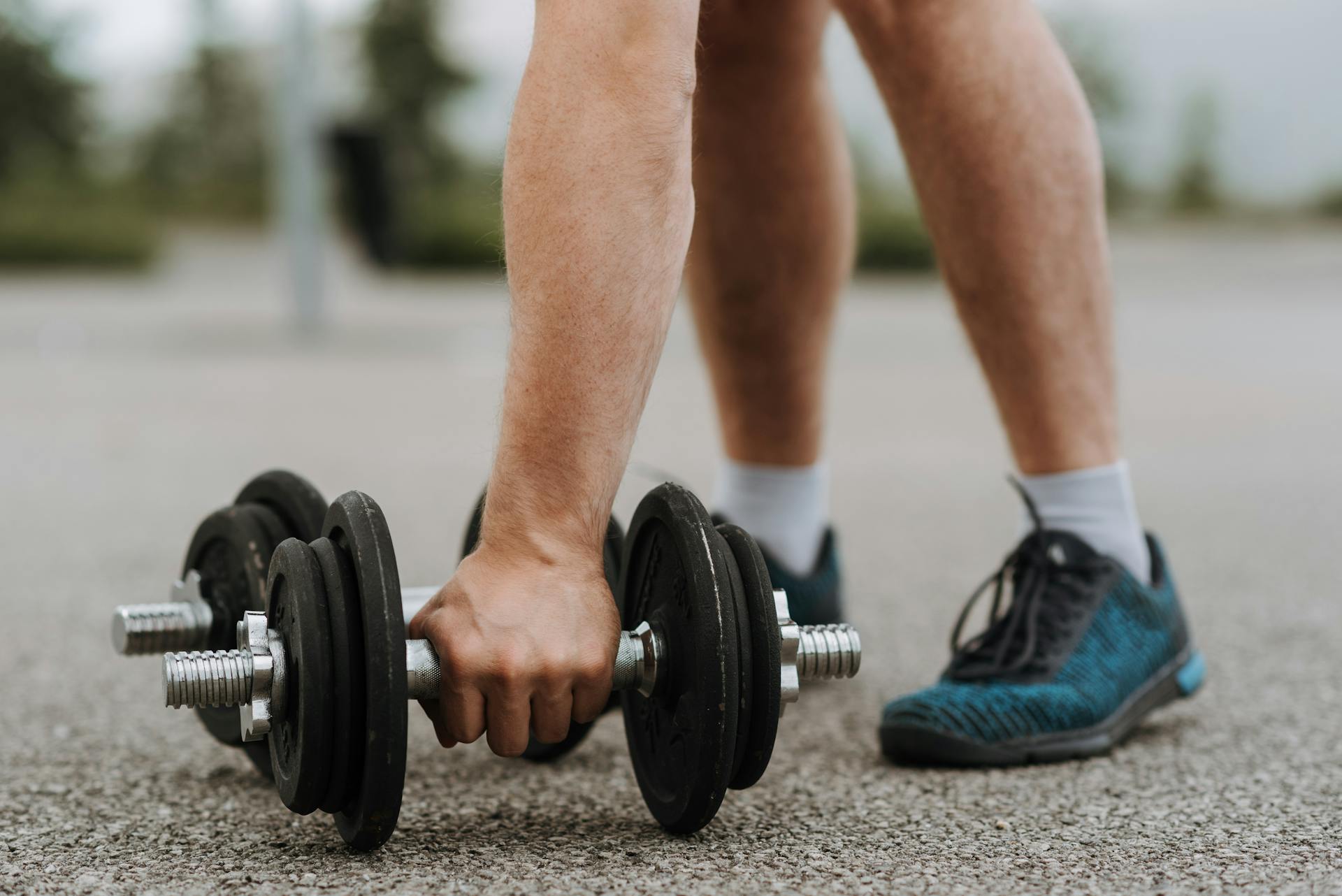 Man touching massive iron dumbbell