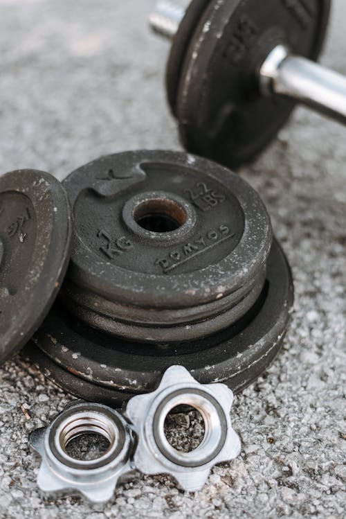 Free Closeup of details for regulating weight of dumbbells for weight training on ashpalt ground Stock Photo